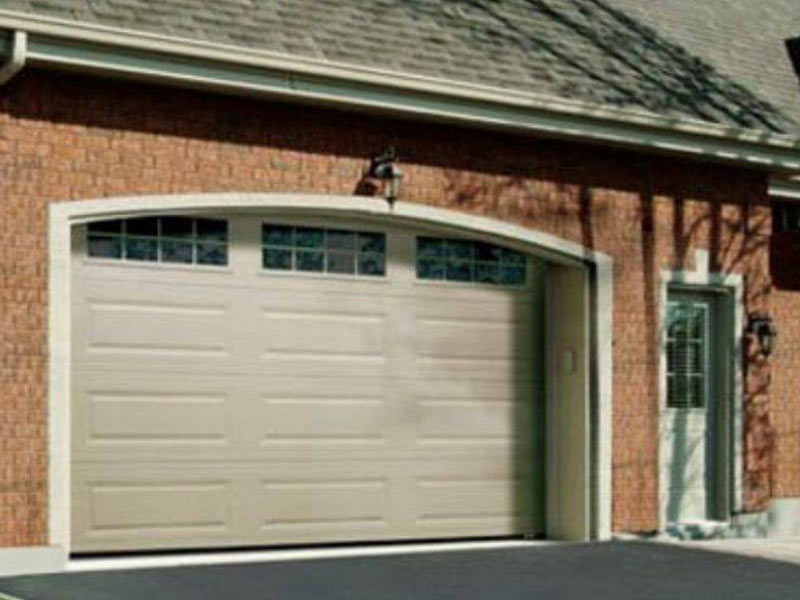 Tan garage door with 3 windows at the top